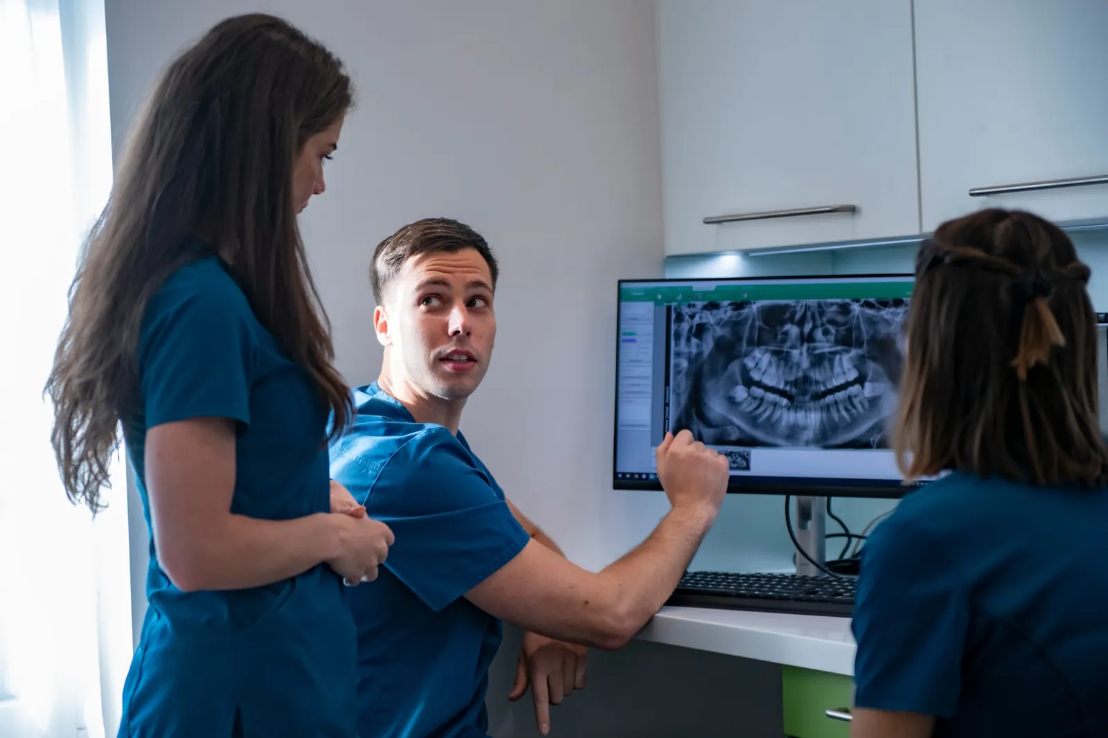 A Trendo Dental csapata közösen tekint át egy panorámaröntgen-felvételt a rendelő monitorján